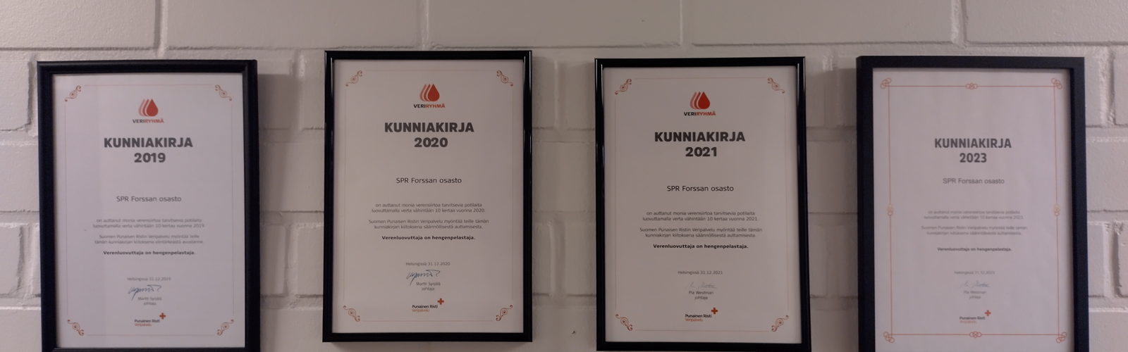 veriryhmän kunniakirjat seinällä
