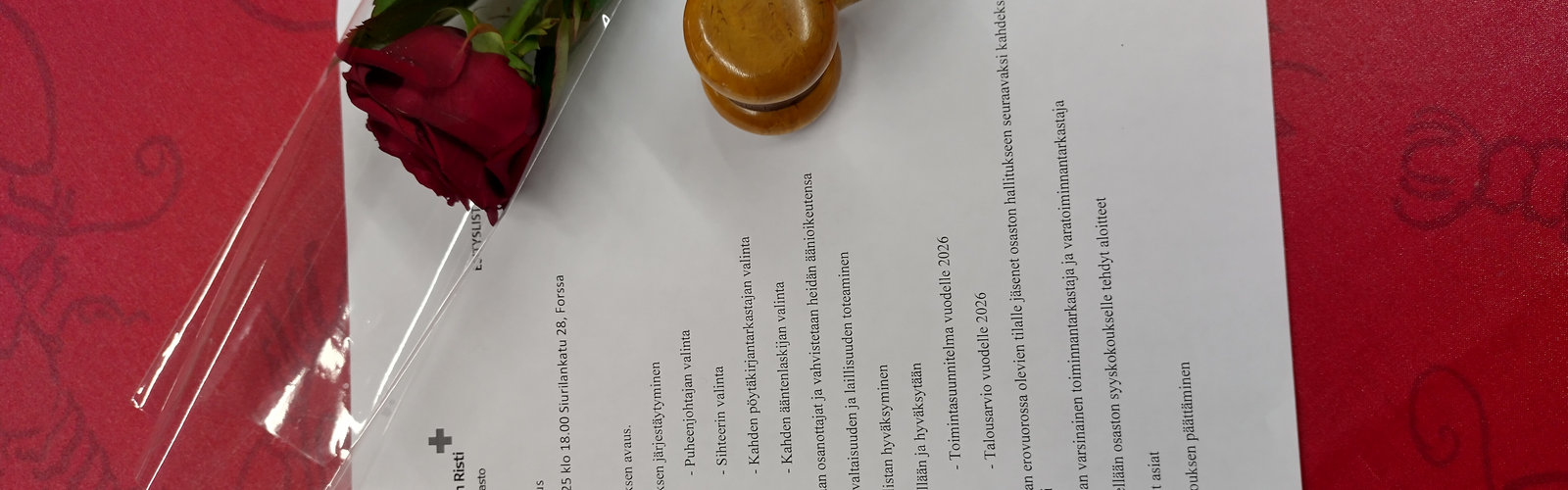 kokouksen asialista, puheenjohtajan nuija ja punainen ruusu