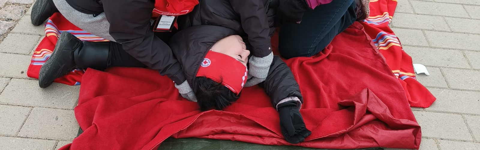 Vapaaehtoiset opettivat paikallisia mitä tehdä tilanteessa, jossa ihminen löytyy maasta makaamassa. (tilanne on näytelty)