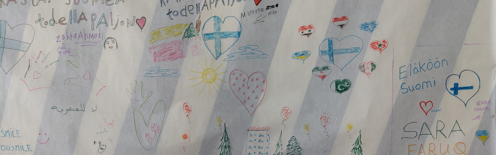 Seinällä paperi jossa kirjoituksia ja piirrustuksia