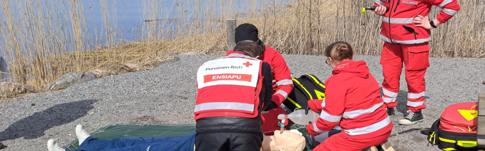 Ensiapuharrastajat harjoittelevat Anne-nuken kanssa rantakalliolla