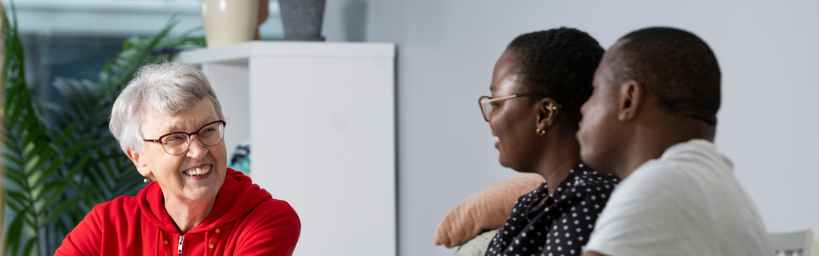 kolme ihmistä yhdessä kahvilla