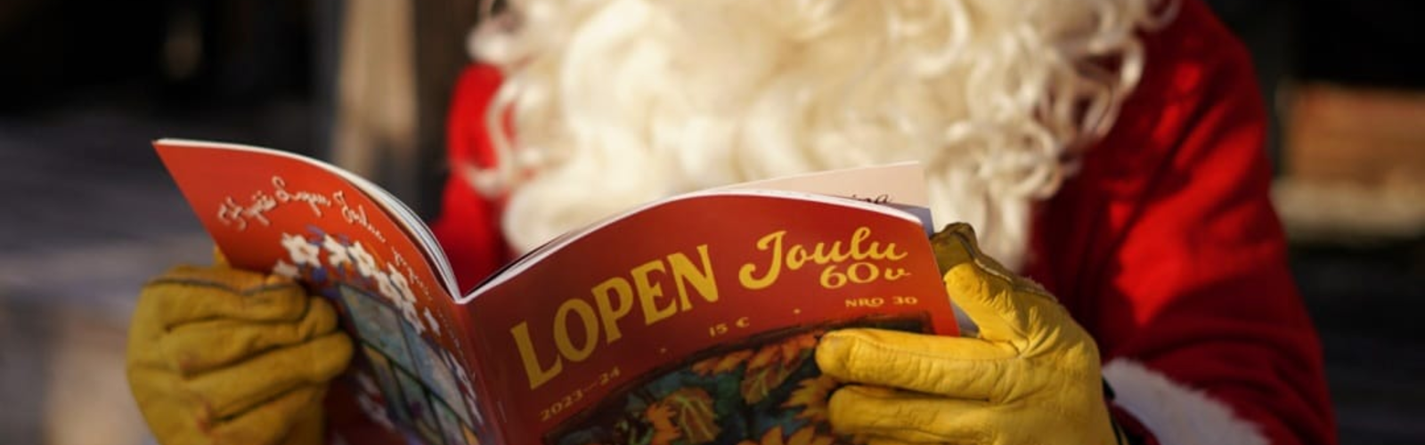 Joulupukki selaa Lopen Joulu -lehteä Vihtijärven joulutorilla