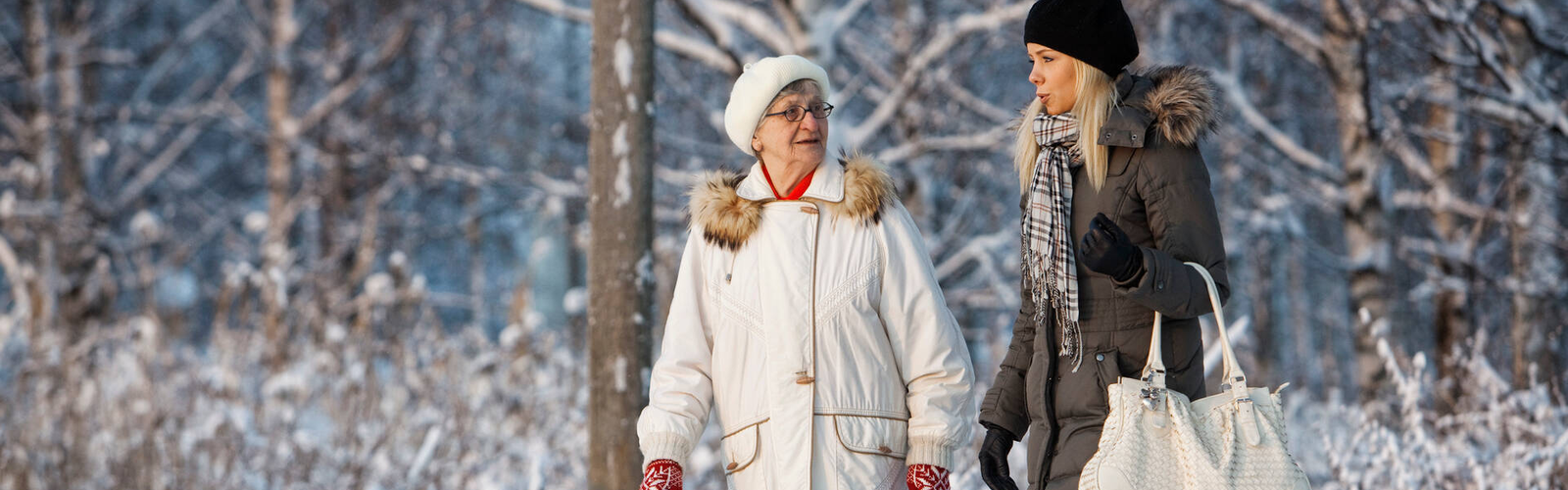 Kaksi henkilöä kävelee talvisessa maisemassa.
