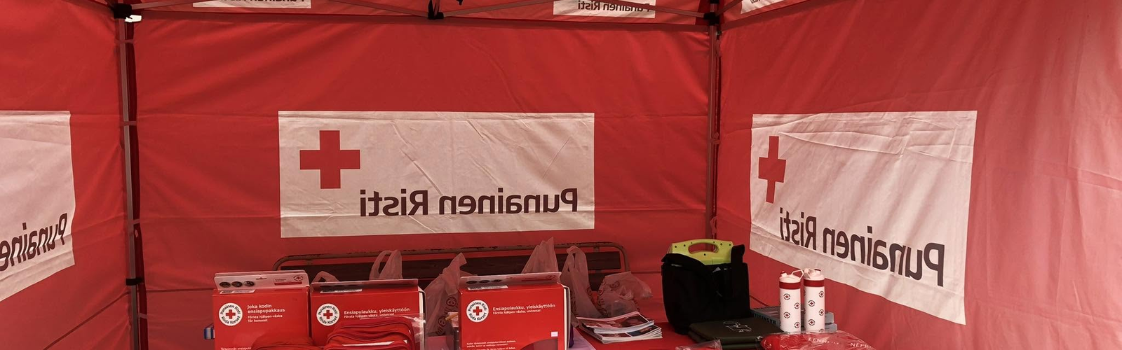 Kuva Punaisen Ristin osaston teltasta, jossa pöydällä esittelymateriaalia