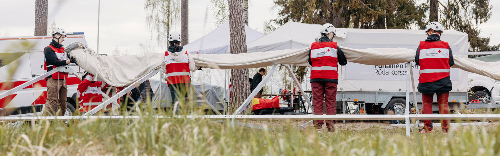 Vapaaehtoiset kokoavat telttaa.