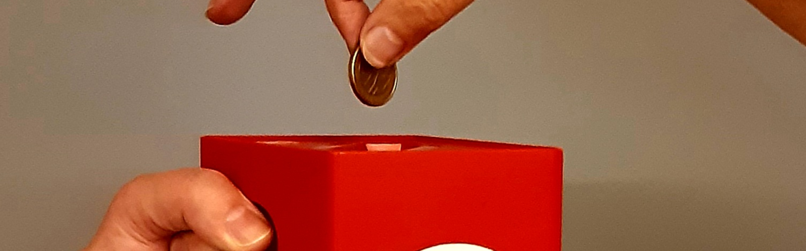 Rahaa lahjoitetaan keräyslippaaseen.